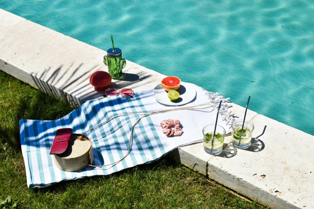 A refreshing summer poolside setup with drinks and accessories for a perfect vacation day.