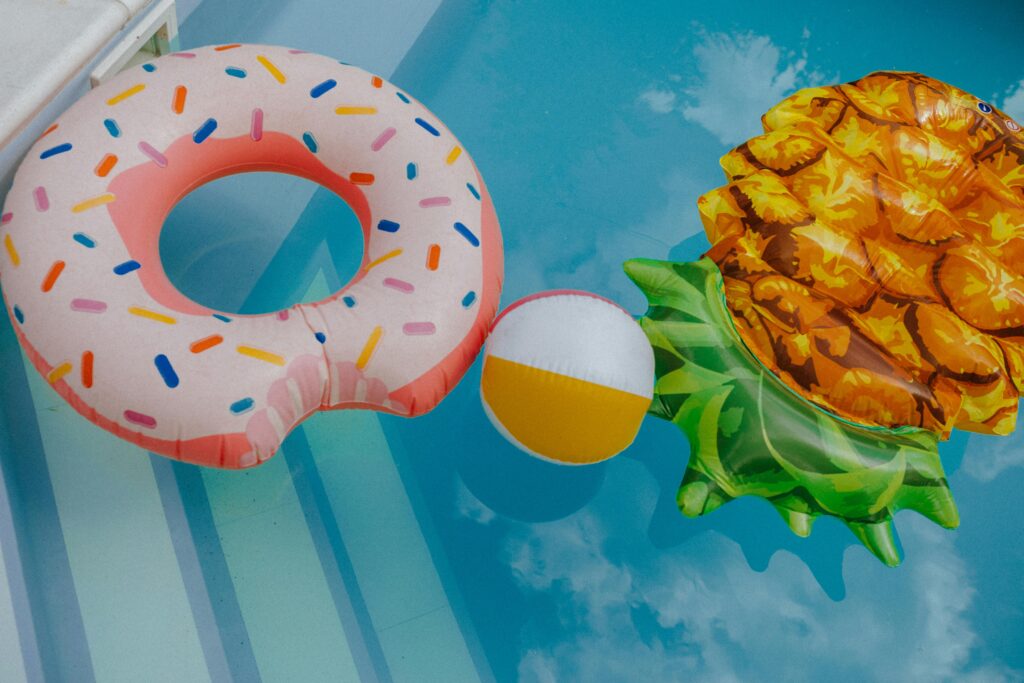A vibrant display of fun pool floats and beach ball in a clear swimming pool.